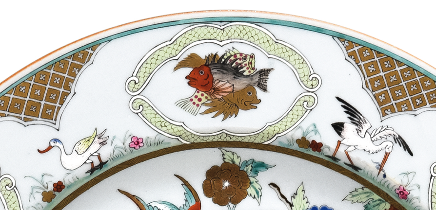 圖為清中期廣彩人物紋大碟細節(jié)圖，碟沿對稱開六窗繪魚紋，間繪六組鳥禽紋。（來源：廣州十三行博物館）