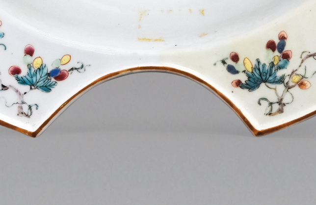 圖為清中期粉彩花卉紋剃須盤細(xì)節(jié)圖，該盤是男士剃胡須時(shí)使用的，弧形缺口能夠卡住下巴，刮起胡須來更方便。（來源：廣州十三行博物館）